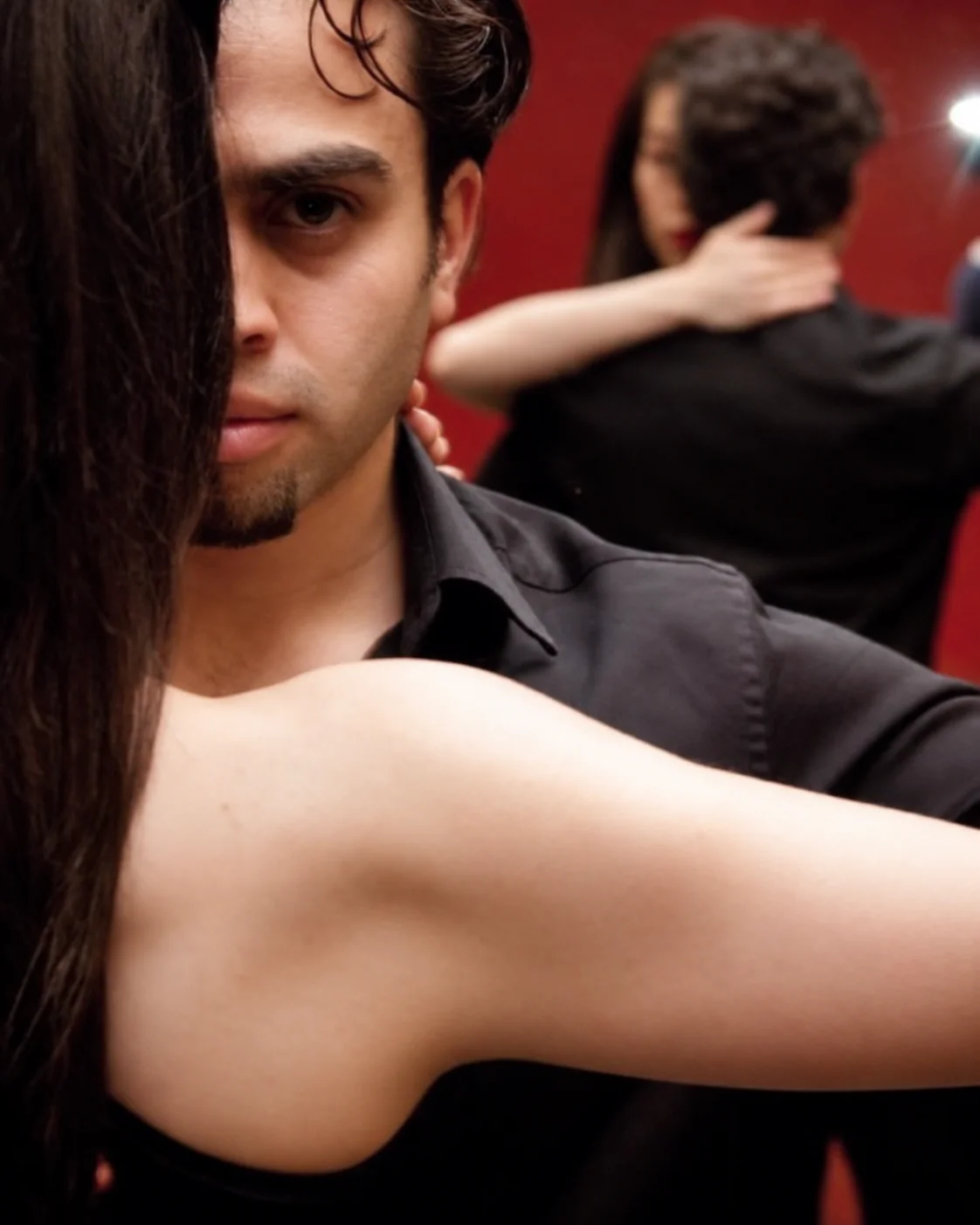 Close-up of Daniel and his dance partner in an embrace, reflected in a mirror.