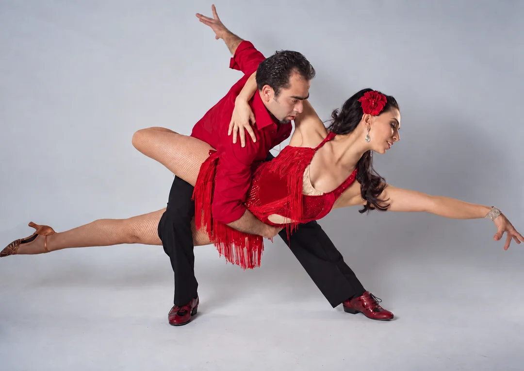 Daniel and his partner in a dynamic dance pose, wearing red.